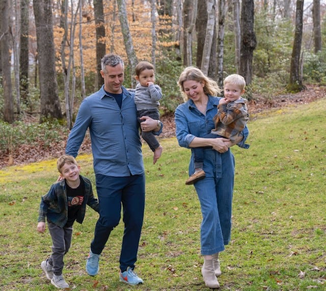 Brett, her husband and their three boys walk outside in the woods, looking happy and content