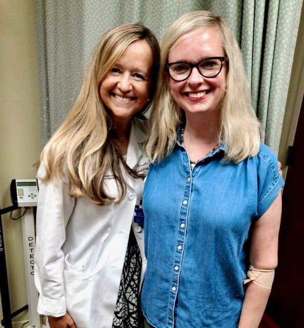 Colleen stands with one of her doctors, smiling brightly, as she marks finishing tamoxifen after five years. 