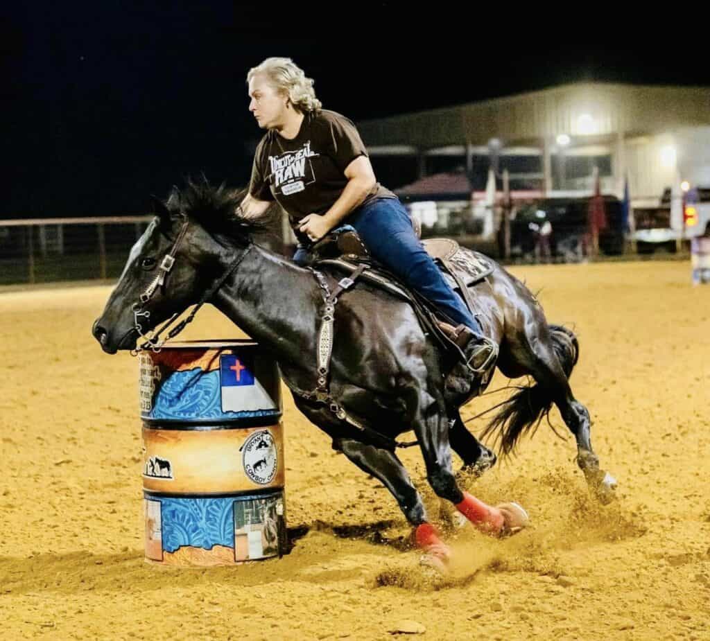 Lisa rides a horse during a barrel racing competition 