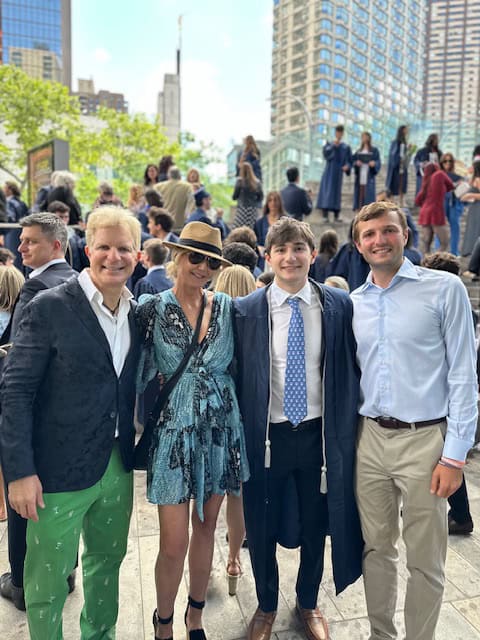 Breast cancer survivor Heather and her family are outside in a city, celebrating a graduation 