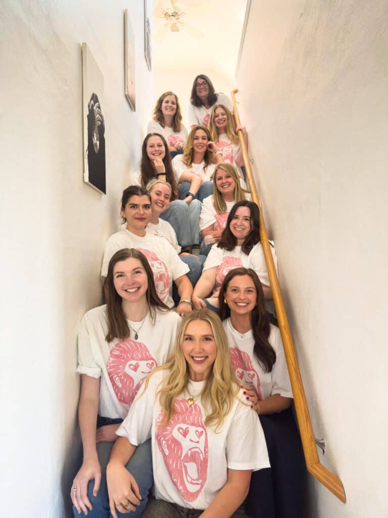 Jennie and her all-female team at the company she owns, sitting on a small staircase